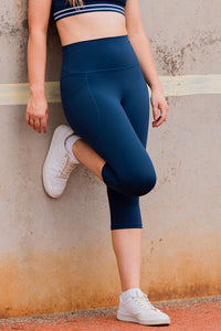 Women wearing navy high waisted leggings with phone pockets.