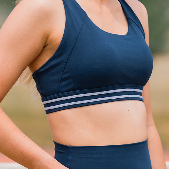Woman wearing a navy pull over sports bra 