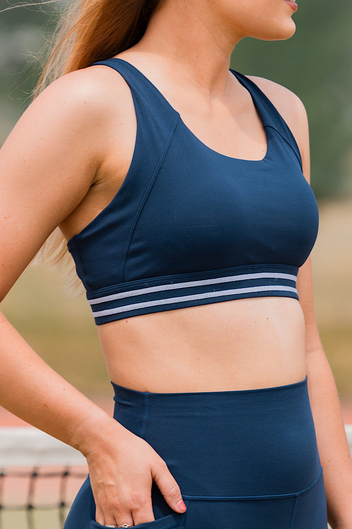 Woman wearing a navy pull over sports bra 