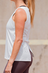 Women wearing a white relaxed sleeveless singlet.