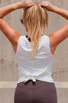 Women wearing a white relaxed sleeveless singlet.