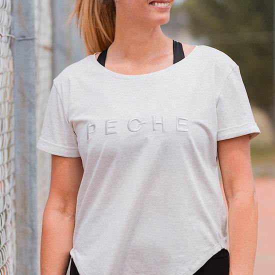 Woman wearing a grey t-shirt with 'PECHE' branding.