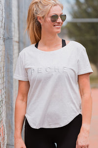 Woman wearing a grey t-shirt with 'PECHE' branding.