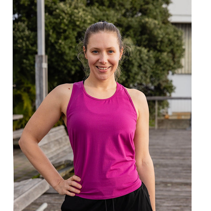 Woman wearing a magenta racer back cotton tank top.