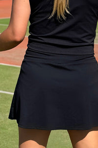 Women wearing black pickle ball skort.