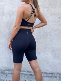women wearing black non roll down shorts and sports bra 