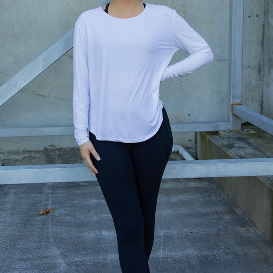 Woman wearing a white long-sleeve uv top and black non roll down leggings