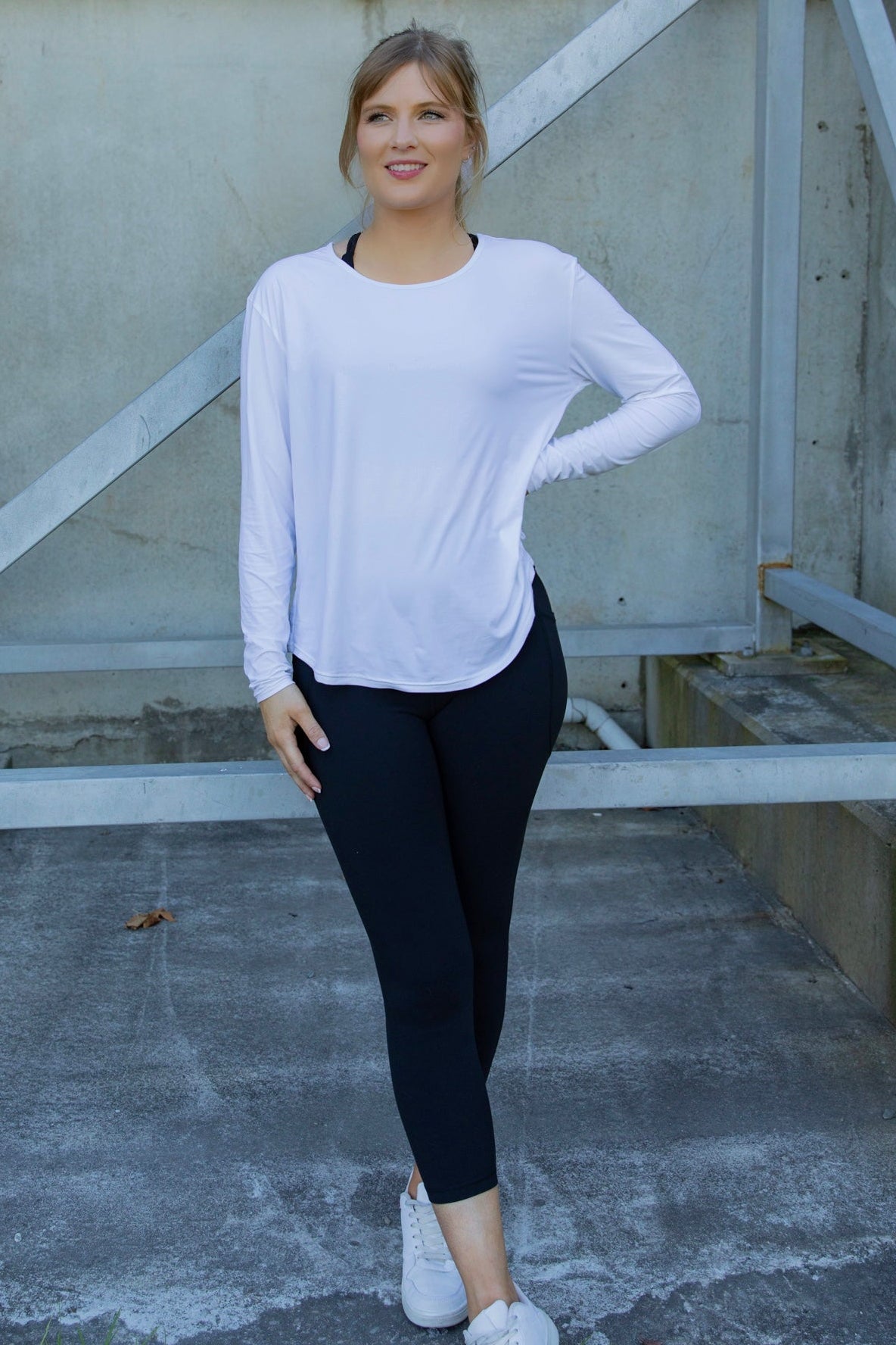 Woman wearing a white long-sleeve uv top and black non roll down leggings
