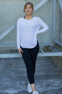 Woman wearing a white long-sleeve uv top and black non roll down leggings