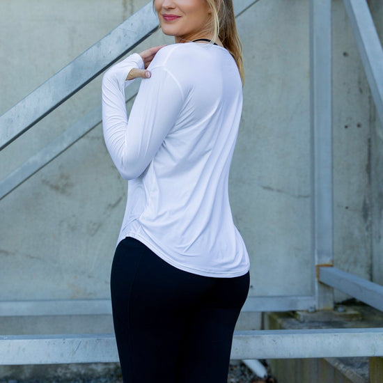 Woman wearing a relaxed white long-sleeve uv top and black non roll down leggings