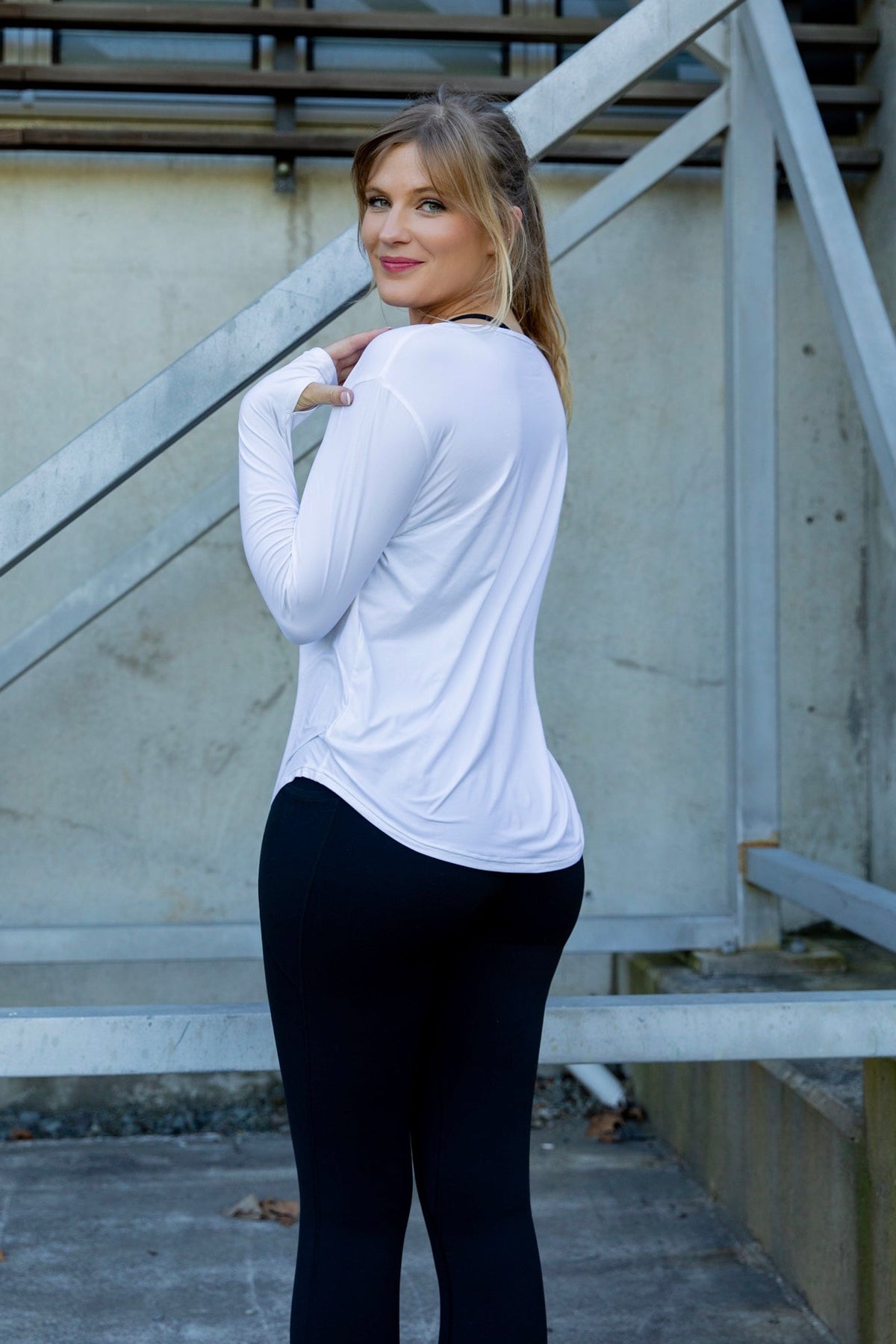 Woman wearing a relaxed white long-sleeve uv top and black non roll down leggings