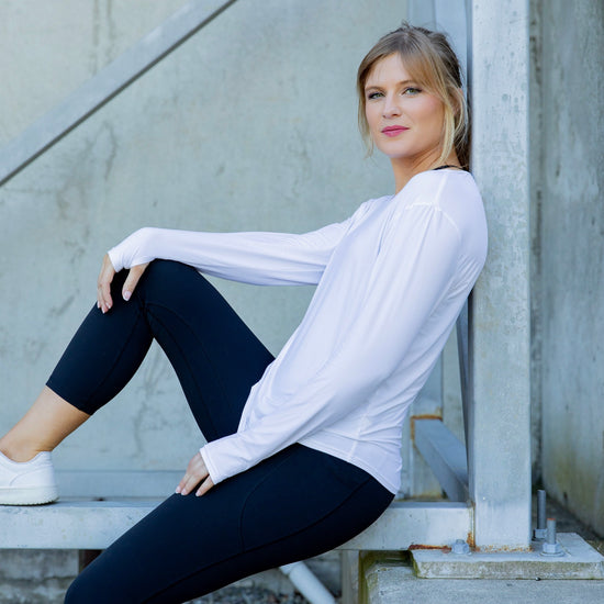 Woman wearing a white long-sleeve uv top and black non roll down leggings