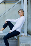 Woman wearing a white long-sleeve uv top and black non roll down leggings