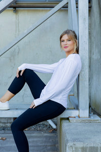 Woman wearing a white long-sleeve uv top and black non roll down leggings