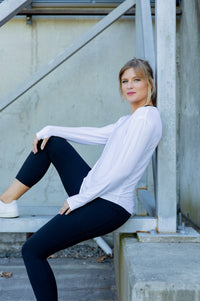 Woman wearing a white long-sleeve uv top and black non roll down leggings
