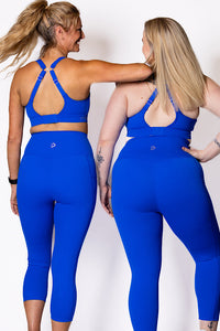 Two women wearing matching blue leggings and bra