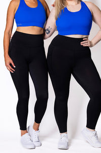 Women wearing full length phone pocket tights with blue sports bra 