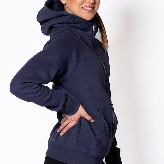 Woman wearing a zip through navy blue hoodie.