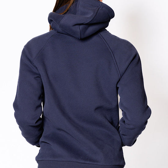 Woman wearing a zip through navy blue jumper.