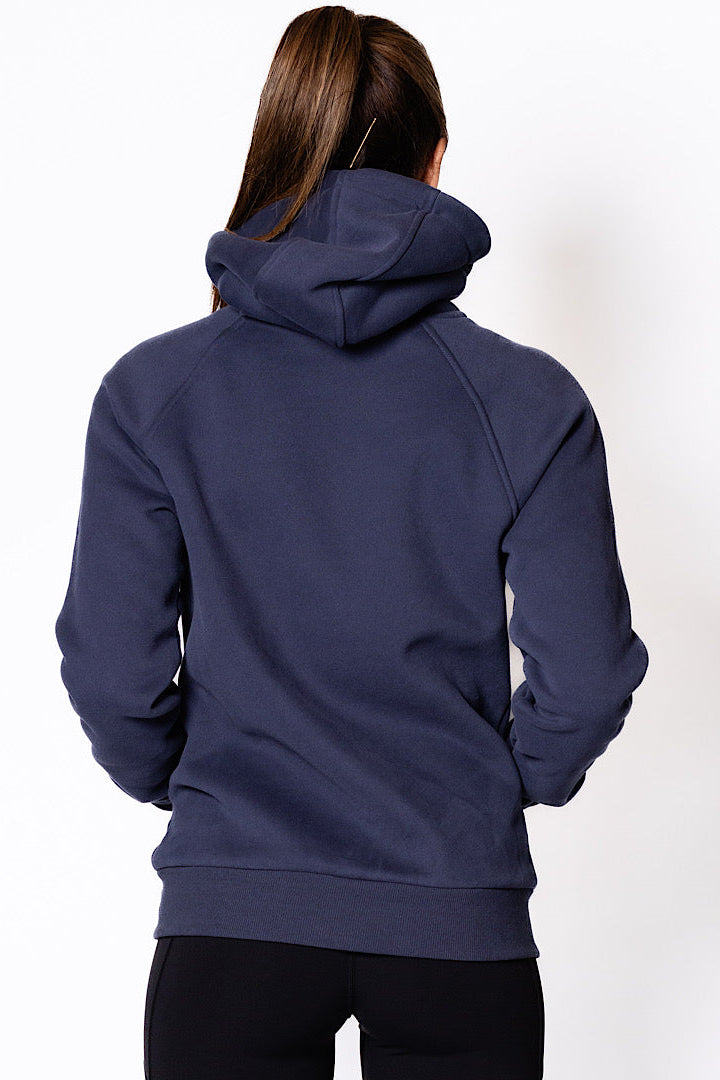 Woman wearing a zip through navy blue jumper.