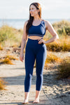Women wearing high waisted navy-blue soft leggings and navy sports bra.
