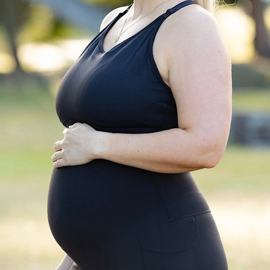 Pregnant woman wearing maternity leggings and maternity bra.
