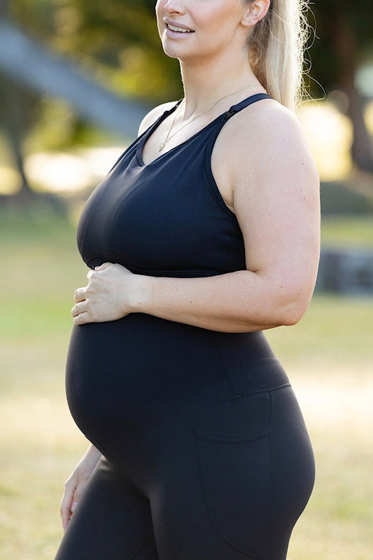 Pregnant woman wearing maternity leggings and maternity bra.