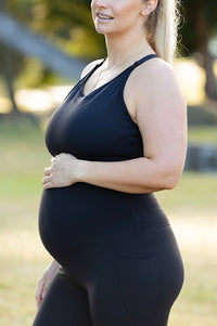Pregnant woman wearing maternity leggings and maternity bra.