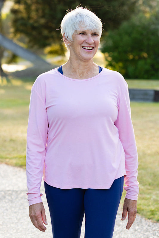 Mature woman wearing a pink long-sleeve top 