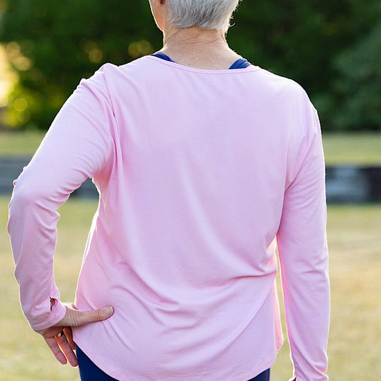 Mature woman wearing a pink long-sleeve top 