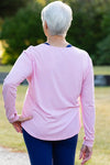 Mature woman wearing a pink long-sleeve top 