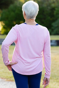Mature woman wearing a pink long-sleeve top 