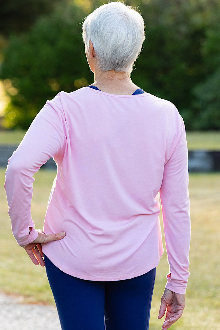 Mature woman wearing a pink long-sleeve top 