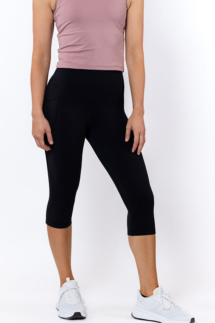 Person wearing black capri leggings and a pink top