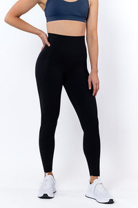 Women wearing high waisted black phone pocket leggings and a navy bra