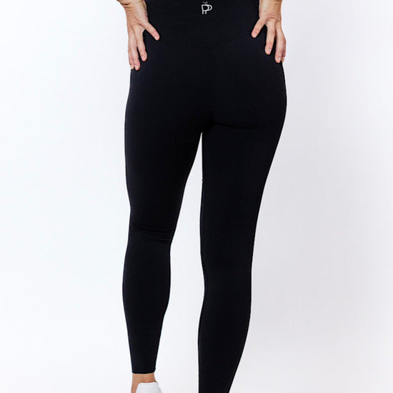 Women wearing high waisted black phone pocket leggings and a navy bra