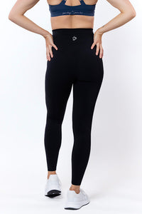 Women wearing high waisted black phone pocket leggings and a navy bra