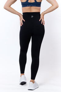 Women wearing high waisted black phone pocket leggings and a navy bra