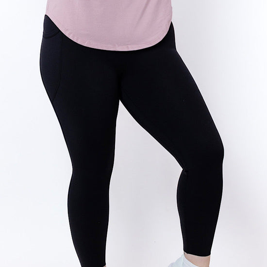 women wearing black leggings and a pink top on a white background