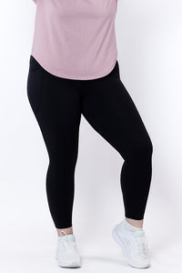women wearing black leggings and a pink top on a white background