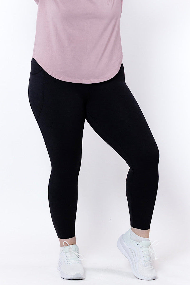 women wearing black leggings and a pink top on a white background