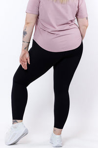 curvy women wearing full length high waisted black phone pocket leggings and a navy bra