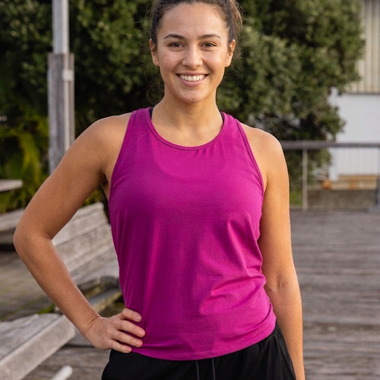 Woman wearing a pink tank top and black pants