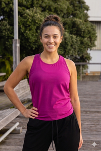Woman wearing a pink tank top and black pants