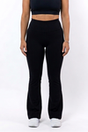 Woman wearing a black sports bra and flare leggings