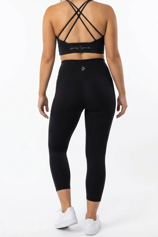 Person wearing a black sports bra and leggings set on a white background