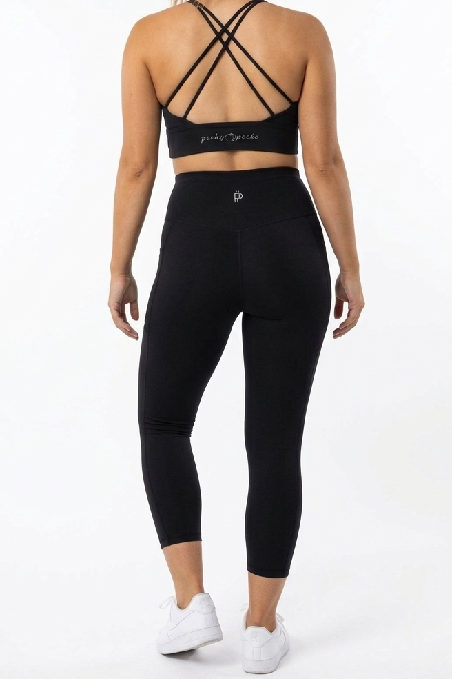 Person wearing a black sports bra and leggings set on a white background