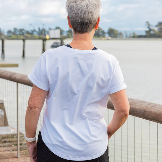 Women wearing a white scoop neck t-shirt and black cotton pants.