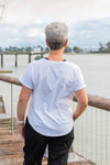Women wearing a white scoop neck t-shirt and black cotton pants.