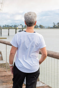 Women wearing a white scoop neck t-shirt and black cotton pants.